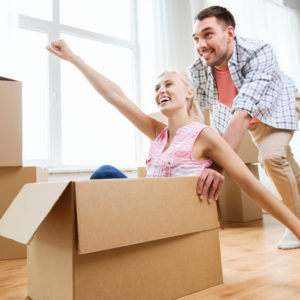 couple with cardboard boxes having fun at new home