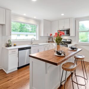 A well lit modern kitchen with white cabinets and an island