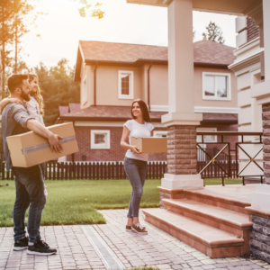 Couple moving in to new home holding boxes