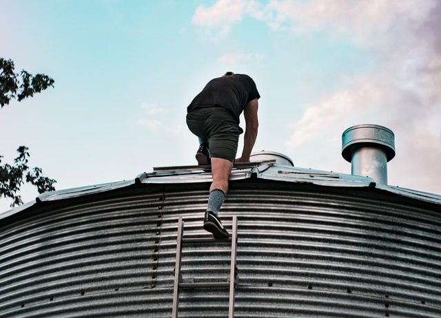 A man climbing on a roof.