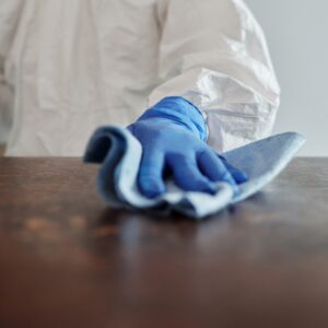 a man in a protective suit cleaning a table