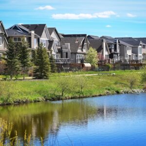 Canadian suburb, row of houses near water, clear sky, green grass