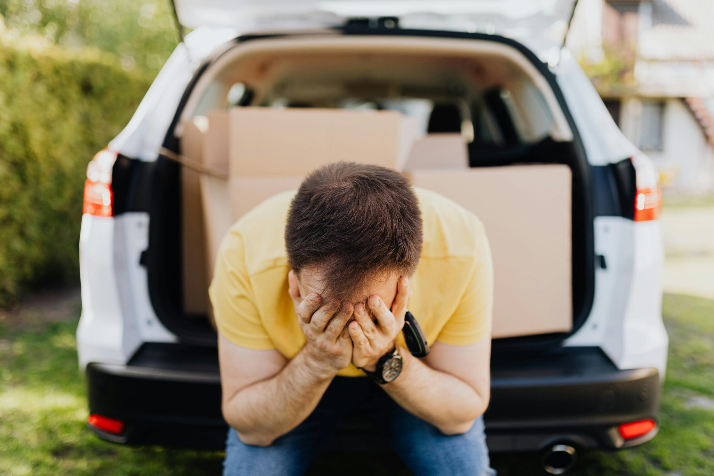 a man stressed with moving boxes in the car